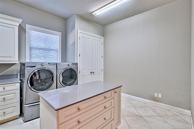 laundry area with cabinet space, washing machine and dryer, light tile patterned floors, and baseboards