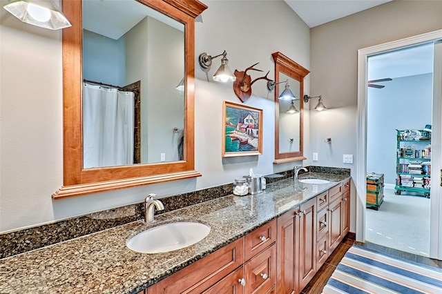 bathroom with double vanity, a sink, and baseboards