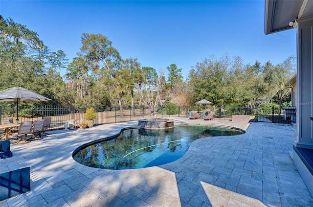 view of swimming pool featuring a patio area, fence, and a pool with connected hot tub