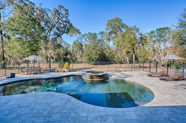 view of swimming pool with a pool with connected hot tub, a patio area, and fence