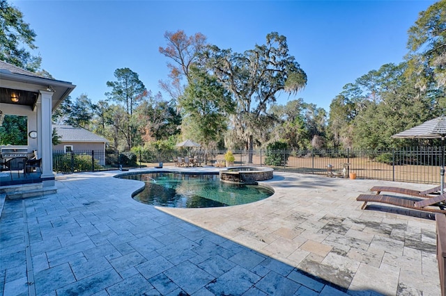 view of pool with a pool with connected hot tub, a patio, and fence