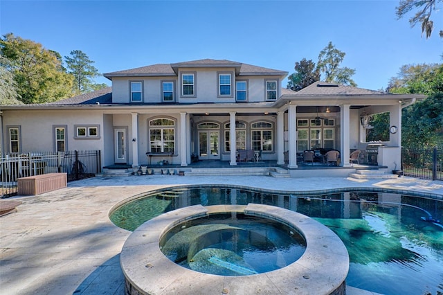 back of property featuring an outdoor pool, fence, a patio, and an in ground hot tub