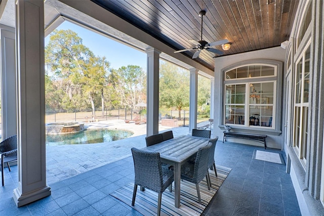 view of patio / terrace featuring a ceiling fan, a pool with connected hot tub, fence, and outdoor dining area