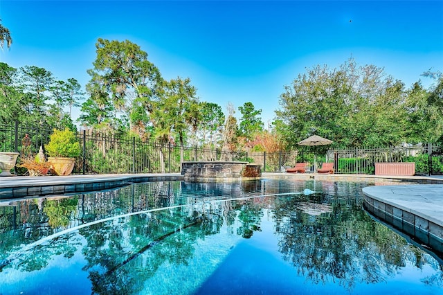 view of swimming pool featuring fence