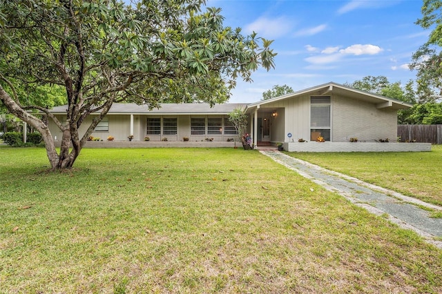 view of front of property with a front yard, fence, and brick siding