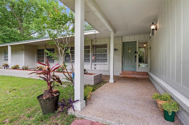 entrance to property with brick siding and covered porch