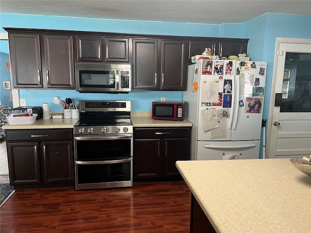 kitchen with light countertops, dark wood-style flooring, and appliances with stainless steel finishes