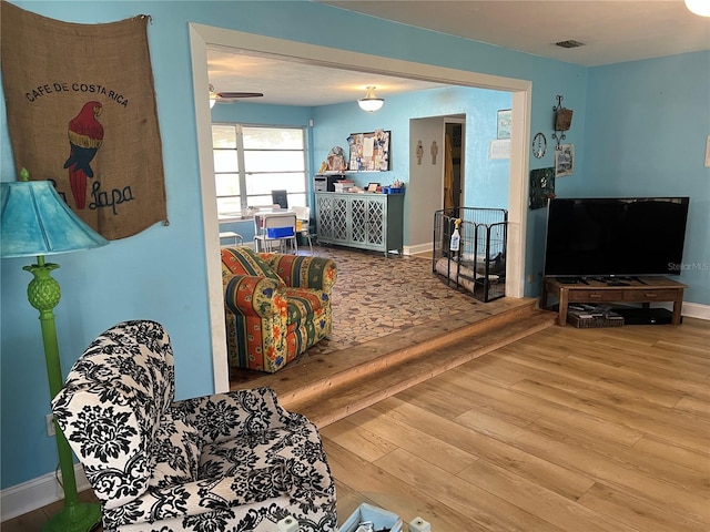 living room featuring visible vents, baseboards, and wood finished floors