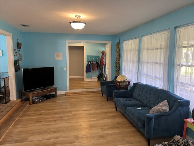 living area with baseboards, visible vents, and light wood finished floors