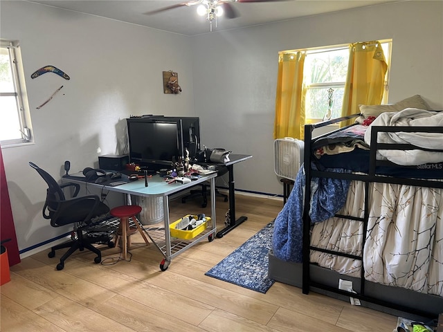 bedroom featuring multiple windows, light wood-type flooring, and ceiling fan