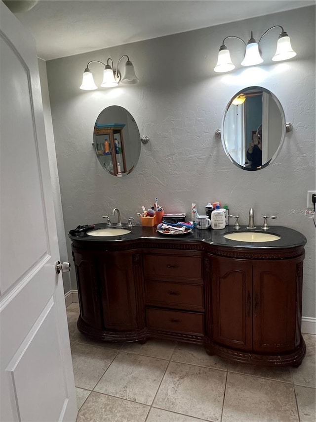 bathroom featuring a sink, double vanity, and a textured wall