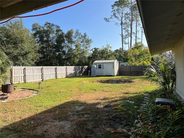 view of yard with a fenced backyard, a shed, and an outdoor structure