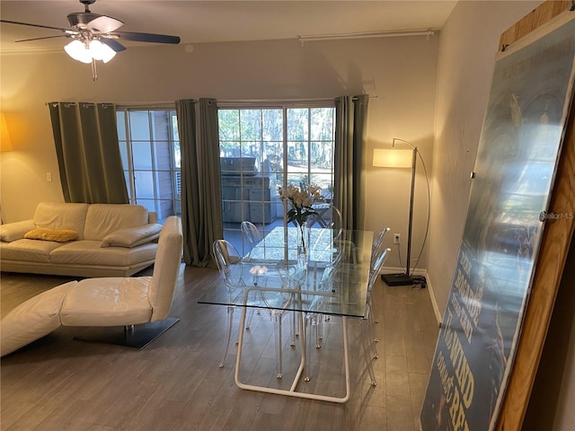 living area with ceiling fan, baseboards, and wood finished floors