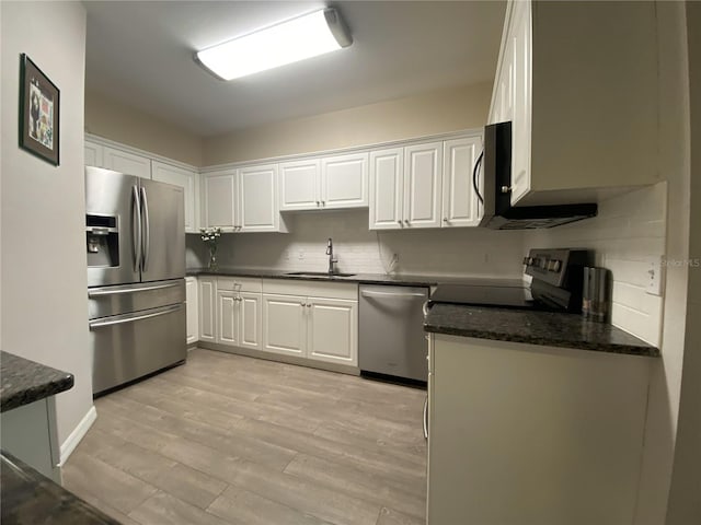 kitchen featuring a sink, stainless steel appliances, light wood finished floors, and white cabinetry