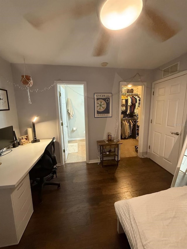 bedroom featuring baseboards, visible vents, dark wood-type flooring, a spacious closet, and ensuite bathroom