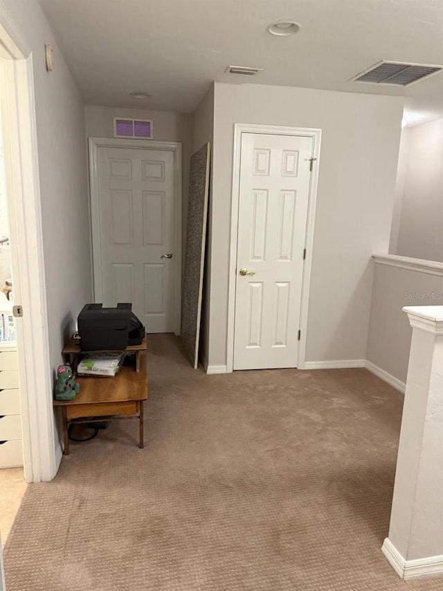 hall with carpet flooring, baseboards, and visible vents