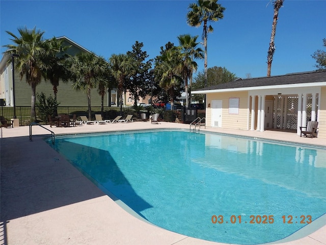 pool featuring fence and a patio area