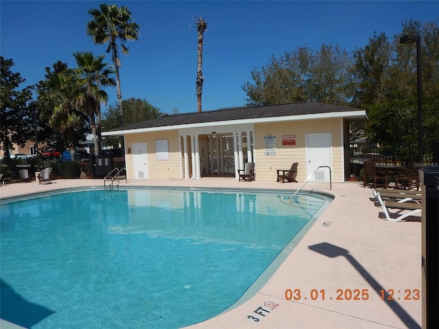 community pool with a patio area and fence