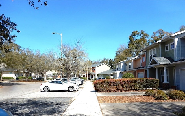 view of street featuring curbs, a residential view, and street lights