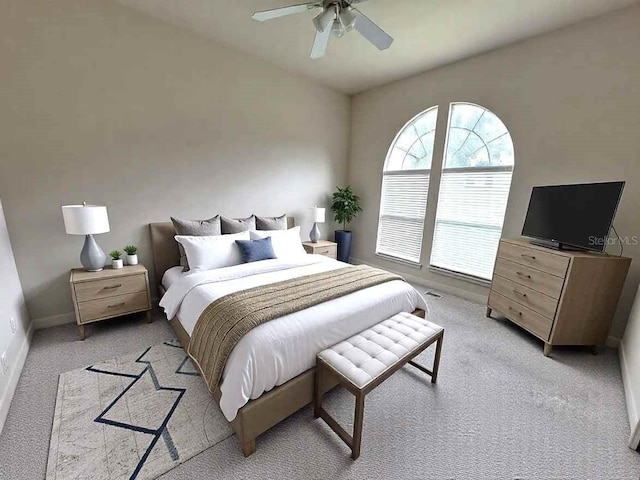 bedroom with light carpet, ceiling fan, and baseboards