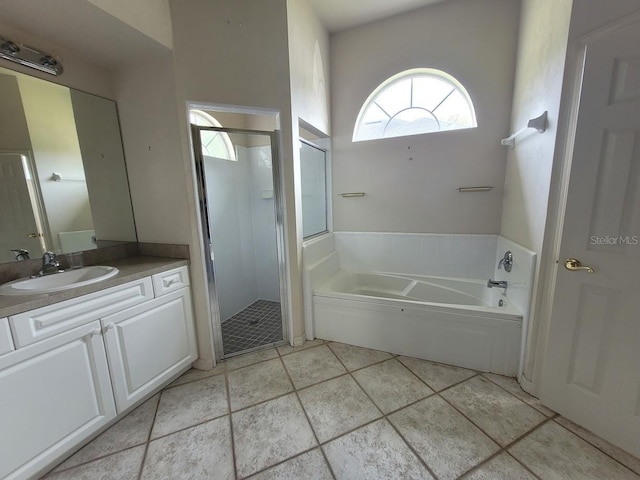 full bathroom featuring tile patterned floors, a shower stall, vanity, and a bath