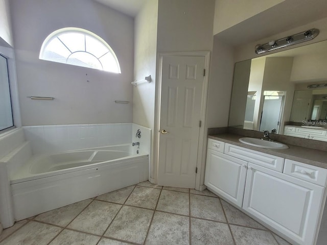 bathroom with a garden tub, vanity, and tile patterned floors