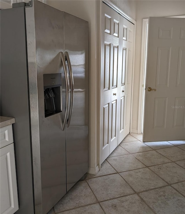 kitchen featuring light tile patterned floors, white cabinetry, and stainless steel fridge with ice dispenser