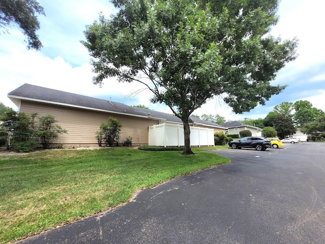 view of property exterior with a yard and fence