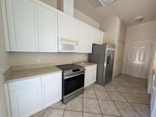 3441 NW 104th Way, Gainesville, FL 32606 - kitchen with light countertops, white cabinetry, appliances with stainless steel finishes, and light tile patterned floors