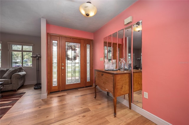 foyer entrance featuring baseboards and wood finished floors