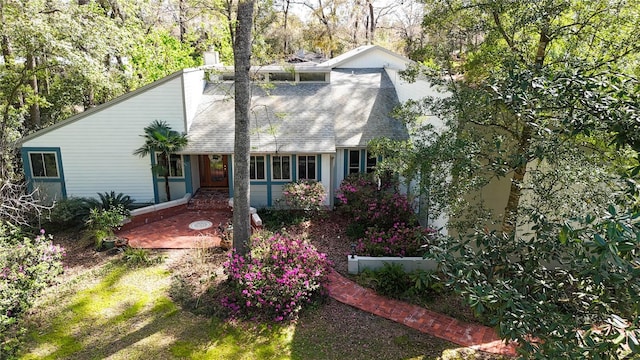 view of front of property with roof with shingles and a chimney