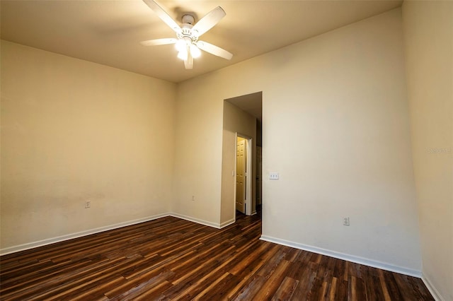 unfurnished room featuring dark wood-type flooring, ceiling fan, and baseboards