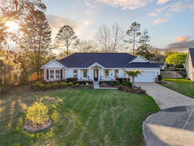 single story home featuring a yard, driveway, an attached garage, and fence