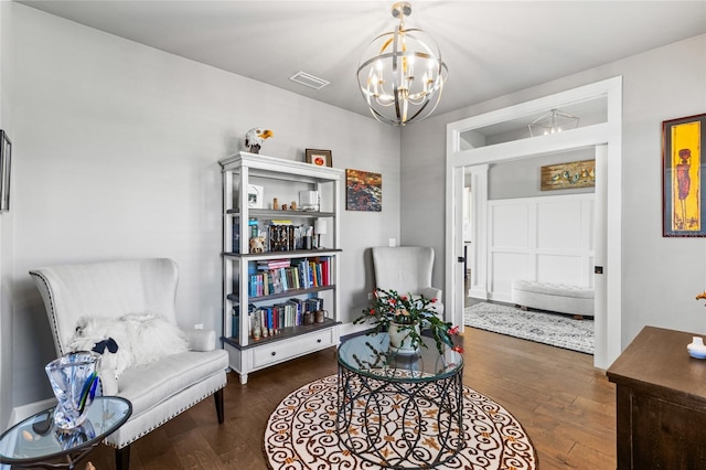 sitting room with visible vents, a notable chandelier, and wood finished floors