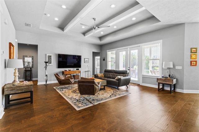 living area with visible vents, baseboards, dark wood-style floors, and a ceiling fan