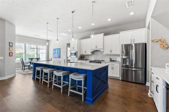 kitchen featuring tasteful backsplash, visible vents, appliances with stainless steel finishes, and dark wood-style floors