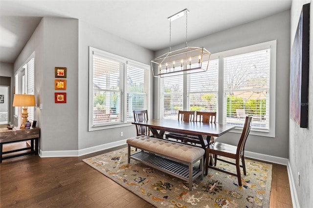 dining area with plenty of natural light, baseboards, and dark wood-style flooring