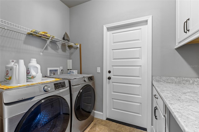 laundry area with cabinet space, light tile patterned floors, and washing machine and dryer