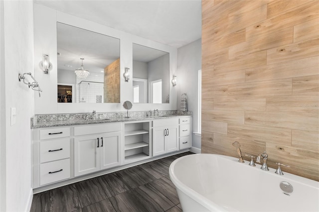 bathroom with double vanity, a freestanding tub, and a sink