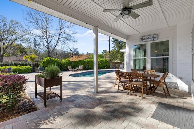 view of patio featuring fence, outdoor dining area, a ceiling fan, and a fenced in pool