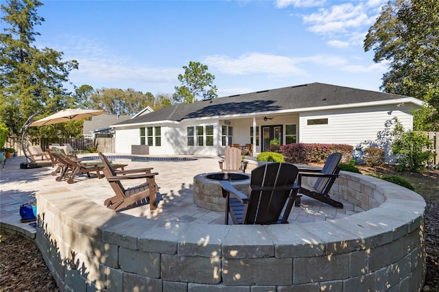 rear view of house featuring a patio area, fence, and an outdoor fire pit