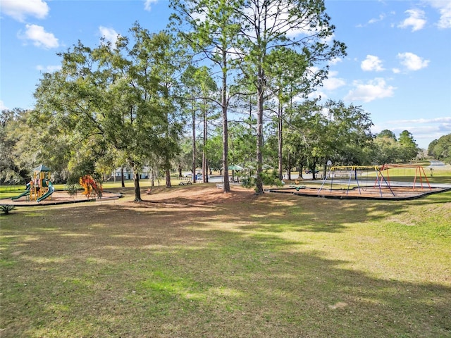 view of property's community with a lawn and playground community