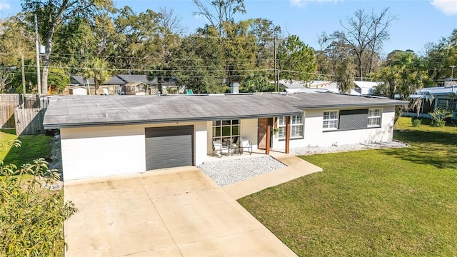 ranch-style house featuring a garage, driveway, covered porch, and a front yard