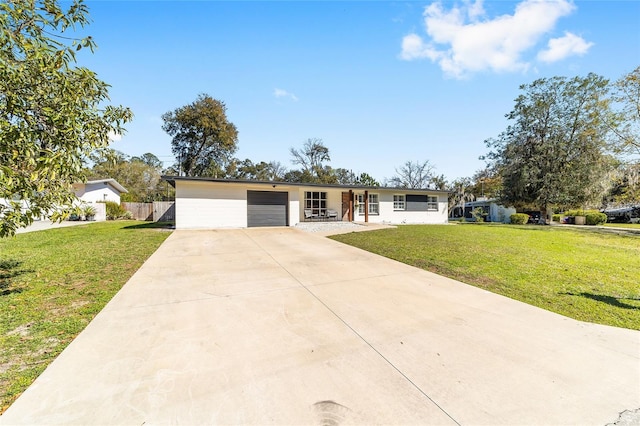 ranch-style house featuring driveway, a garage, fence, and a front yard