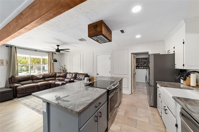 kitchen with a kitchen island, visible vents, open floor plan, appliances with stainless steel finishes, and gray cabinets