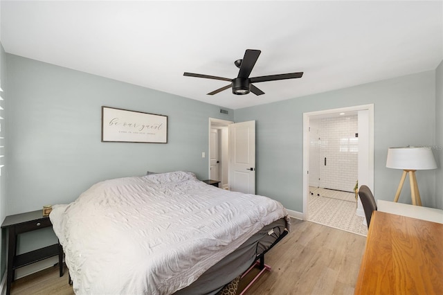 bedroom featuring baseboards, visible vents, a ceiling fan, ensuite bath, and light wood-type flooring