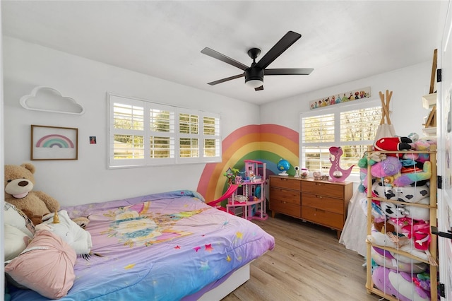 bedroom featuring a ceiling fan, multiple windows, and wood finished floors