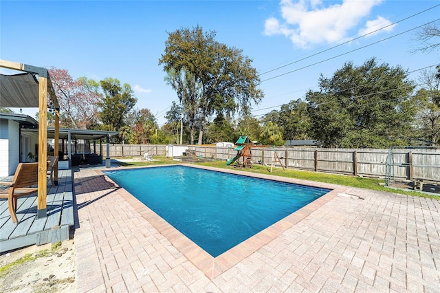 view of swimming pool with a fenced in pool, a fenced backyard, a patio, and a playground