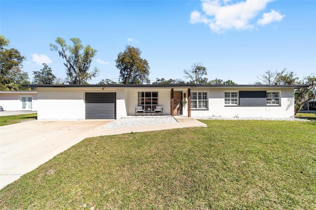 ranch-style house featuring a front yard, driveway, and an attached garage