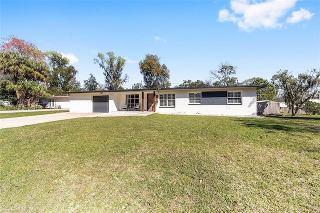 ranch-style home with driveway, a front lawn, and an attached garage